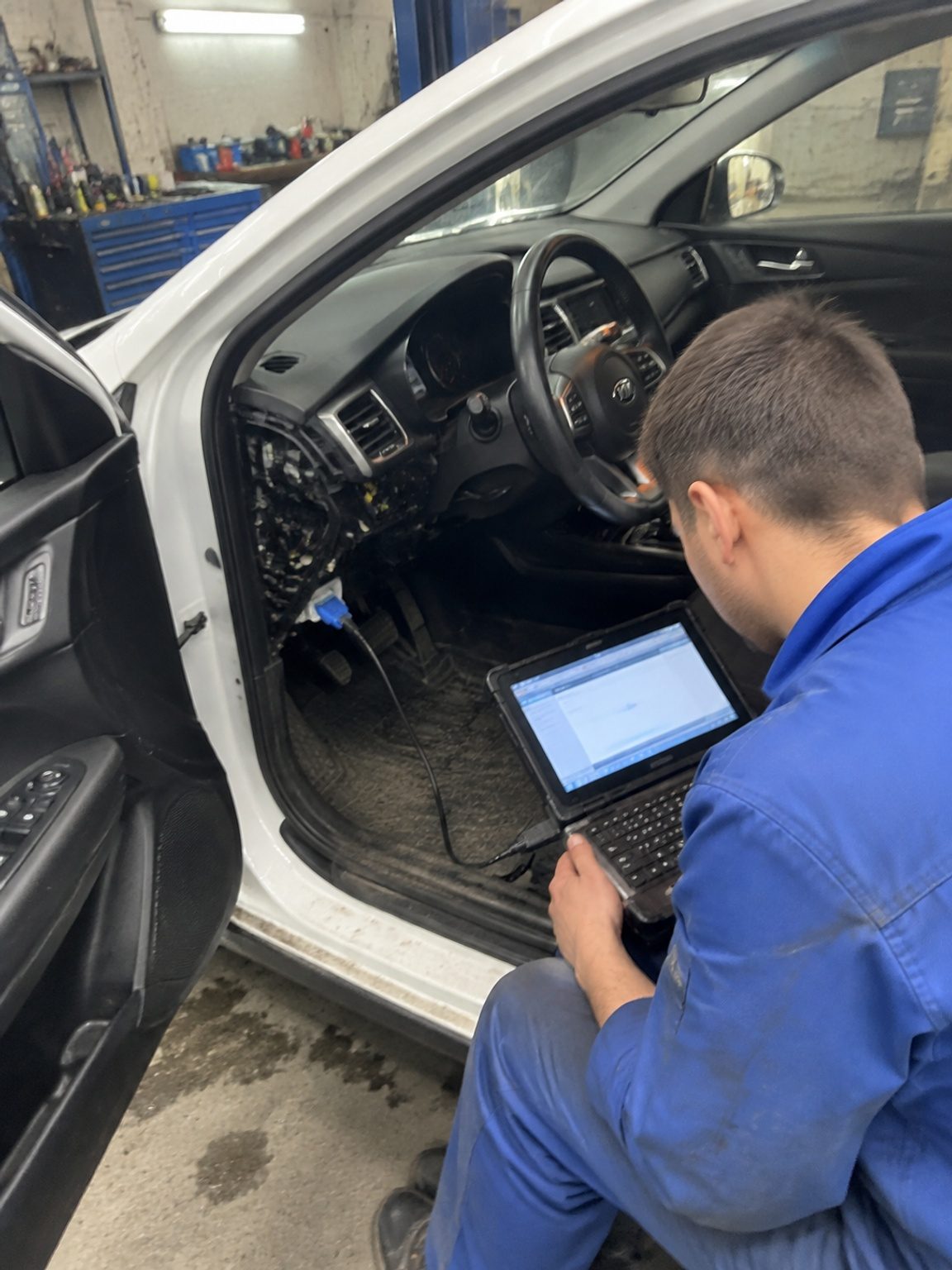 Мастер подключает OBD-II сканер к KIA